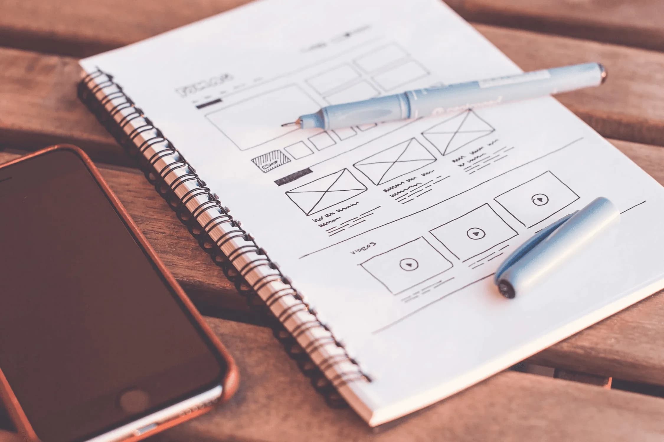A wireframe notebook beside a tablet